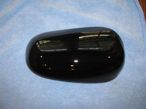 2003 Mercury Marauder - A black side mirror with an integrated turn signal is shown, resting on a blue cloth. The registry claims it is from a 2003 Mercury Maraude…