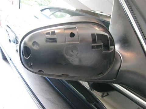 2003 Mercury Marauder - Close-up of a car's side mirror housing, revealing its internal structure and mounting points.