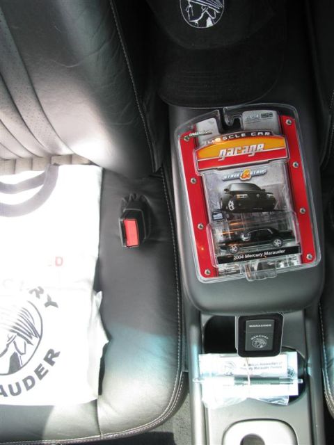 2003 Mercury Marauder - A toy 2004 Mercury Marauder is displayed in its packaging on the center console of a car, next to a t-shirt.