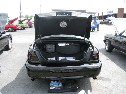 2003 Mercury Marauder - A black sedan with its trunk open, revealing audio equipment and the 'Marauder' nameplate on the rear.