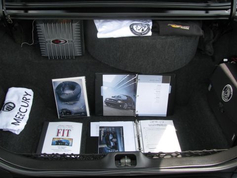 2003 Mercury Marauder - Car trunk contents include brochures, a towel, and audio equipment.