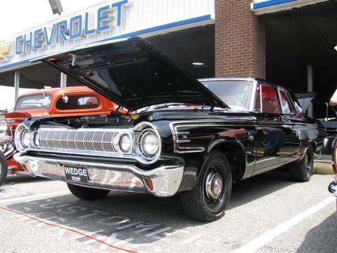 2003 Mercury Marauder - A classic black Dodge Polara is displayed with its hood up at a car show in front of a Chevrolet dealership.