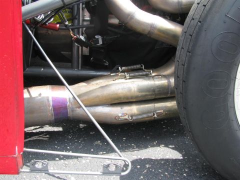 2003 Mercury Marauder - This photo shows a close-up view of a vehicle's exhaust system and a tire, with a red body panel on the left.