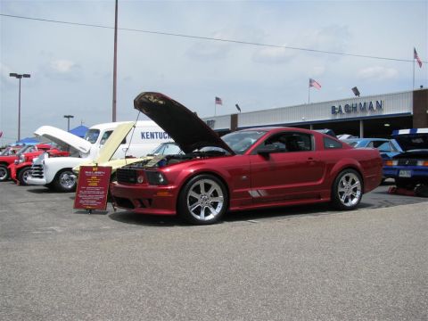 2003 Mercury Marauder - A red coupe, likely a Ford Mustang, is displayed with its hood open at the Bachman Chevrolet Car Show.