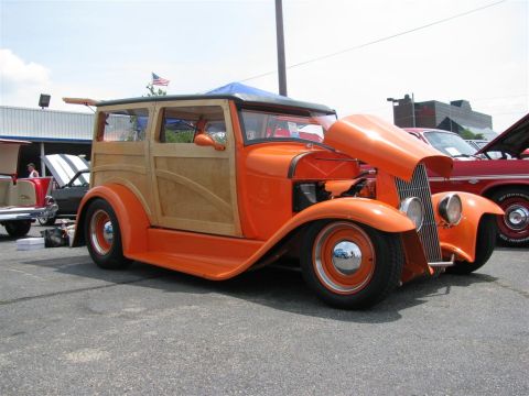 2003 Mercury Marauder - A custom orange woody hot rod is displayed at an outdoor car show.