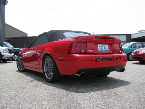 2003 Mercury Marauder - Rear view of a red convertible sports car, identified as a Cobra, parked outdoors with other vehicles.