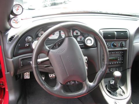 2003 Mercury Marauder - The interior of a car features a steering wheel, dashboard gauges, and a manual transmission shifter.