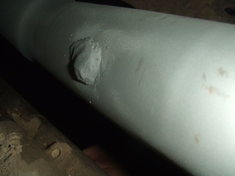 Underbody exhaust pipe with a gray patch