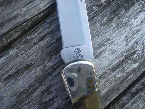 2000 Ford Crown Victoria - Close-up of a Buck Custom USA knife blade and handle resting on aged wooden planks.