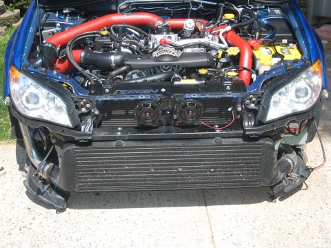 2007 Subaru Impreza - The front of a blue Subaru is shown with the hood open, revealing the engine and aftermarket intercooler system. The front bumper is remove…