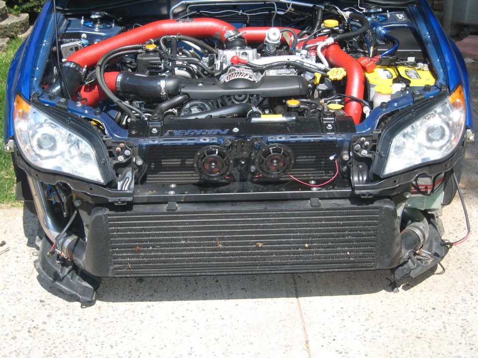 Blue Subaru with bumper removed showing FMIC, Perrin badge, and red-piped turbo boxer engine