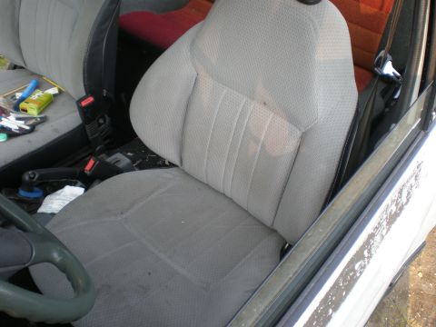 1987 Suzuki Samurai - Interior view of a vehicle's passenger seat and dashboard area, showing worn fabric and a cluttered console.