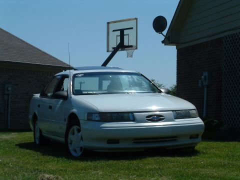 1993 Ford Taurus - White 1992 Ford Taurus sedan parked in a yard on a sunny day.