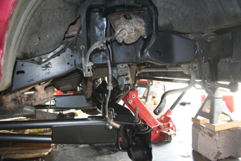 1989 Ford Bronco - The vehicle's front suspension system is disassembled and supported by jack stands for maintenance.
