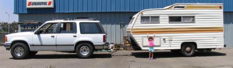1992 Ford Explorer - 1992 Ford Explorer with a travel trailer parked in front of a building.