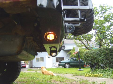 1989 Ford Bronco - Custom rear bumper assembly with integrated light and tow hitch. A green sedan and red car are visible in the background.