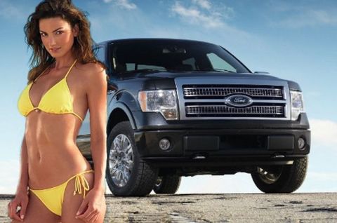 1991 Ford Crown Victoria - A black Ford F-150 truck is parked on a sandy surface with a woman in a yellow bikini standing beside it.