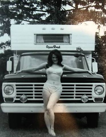 1991 Ford Crown Victoria - A woman poses in front of a vintage camper van, with the "Open Road" branding visible on the camper body.