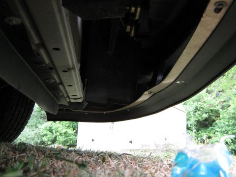 2000 Mercury Grand Marquis - The undercarriage of a vehicle is shown, with a focus on the frame and wheel well area.