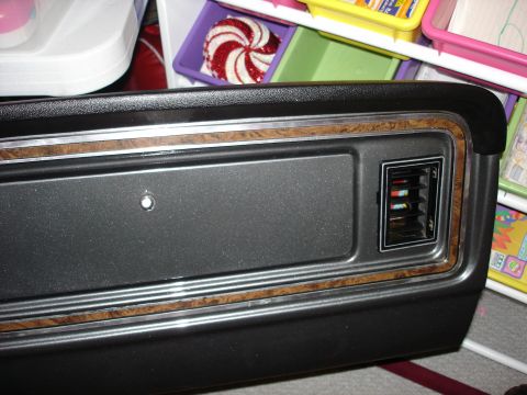 1979 Ford F-250 - Close-up of a vehicle's interior door panel, woodgrain trim and an air vent.