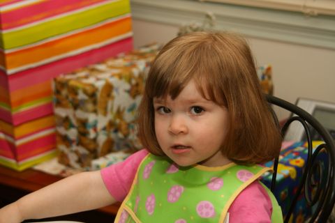 2000 Ford Crown Victoria - A young child sits in a chair, looking towards the camera, with wrapped gifts behind them.