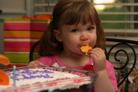 2000 Ford Crown Victoria - A young girl enjoys a snack while sitting at a table with a birthday cake.
