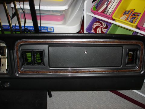 1979 Ford F-250 - Close-up of a vehicle's dashboard trim woodgrain accents and air vents, likely from an older model.