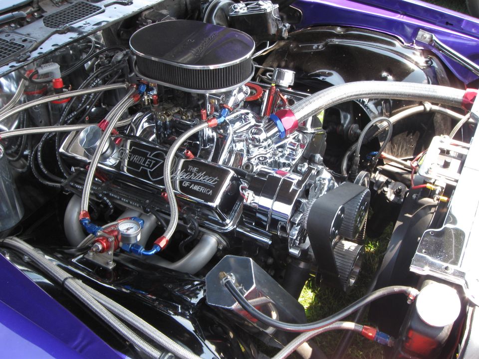 Chrome Chevrolet engine with "The Heartbeat of America" valve cover, purple body panels, and braided hoses