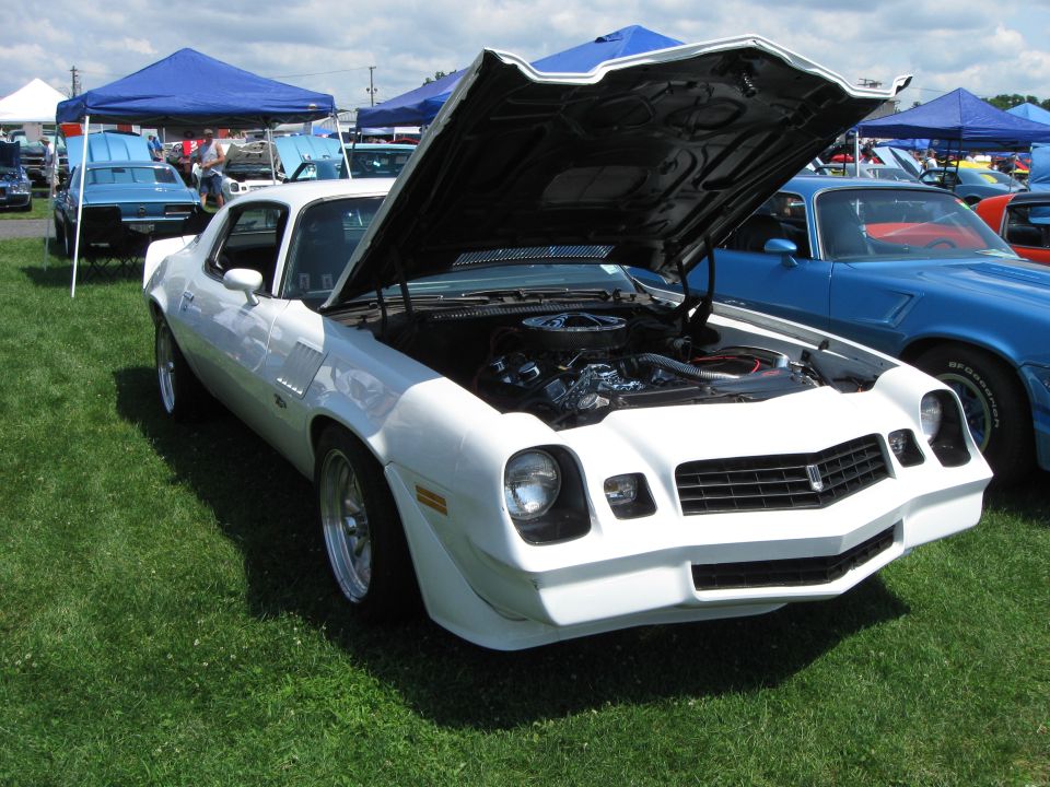White 1978 Chevrolet Camaro front 3/4 view, hood open, parked on grass