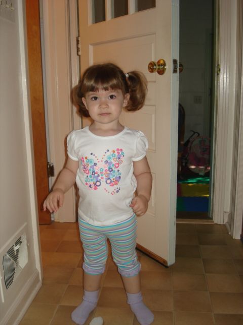 2000 Ford Crown Victoria - A young girl with pigtails and a butterfly-themed shirt stands in a hallway, looking towards the camera.