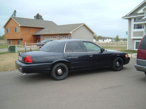 2000 Ford Crown Victoria - Side view of a black 2000 Ford Crown Victoria parked in a residential driveway.