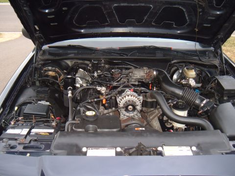 2000 Ford Crown Victoria - The engine bay of a vehicle is shown with various components and a website logo.
