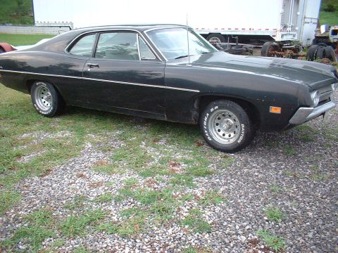 1970 Ford Falcon - A black 1970 Ford Falcon coupe is viewed from the front three-quarter angle, parked outdoors on a gravel lot.