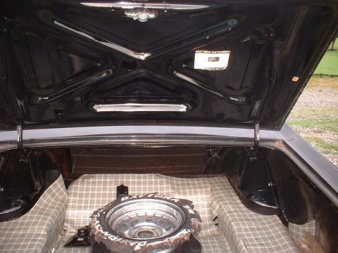 1970 Ford Falcon - The interior of a car trunk, showing the spare tire and lining, with a sticker on the lid.