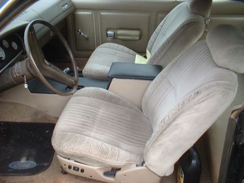 1970 Ford Falcon - The interior of a car features cloth seats and a center console. A Ford logo is visible on the driver's side floor mat.
