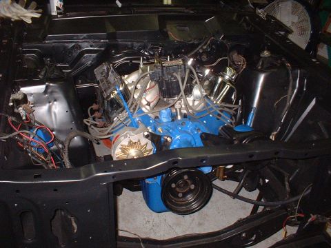 1970 Ford Torino - The engine bay of a vehicle is shown with a blue V8 engine and various components installed.
