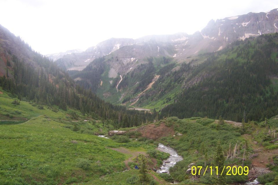Mountain valley scene with a stream and evergreen trees