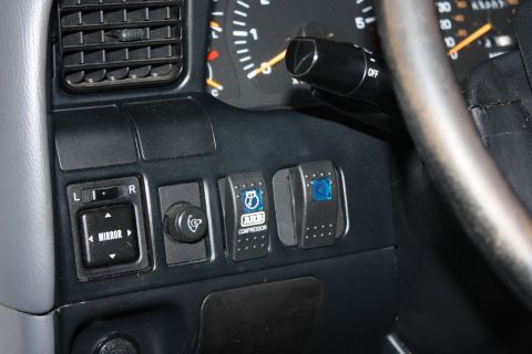 1986 Ford Bronco - Interior view of dashboard controls including mirror adjustment and auxiliary switches.