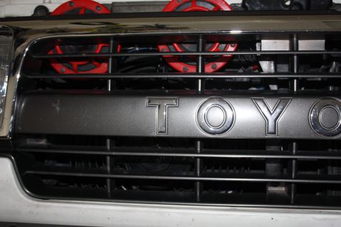 1986 Ford Bronco - Close-up of a vehicle's front grille, showing the TOYO emblem and red aftermarket horns.
