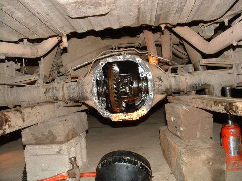 1988 Ford F-150 - Truck's rear differential is exposed for maintenance, resting on blocks with a jack nearby.