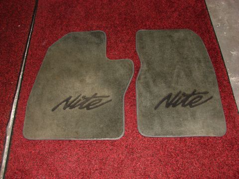 1984 Ford F-250 - A pair of floor mats with the "Nite" designation are shown against a red carpet background.