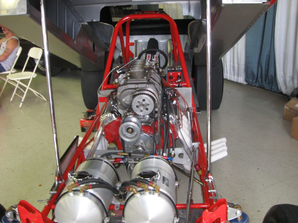 Dragster chassis with exposed V8 engine, dual fuel tanks, and roll cage