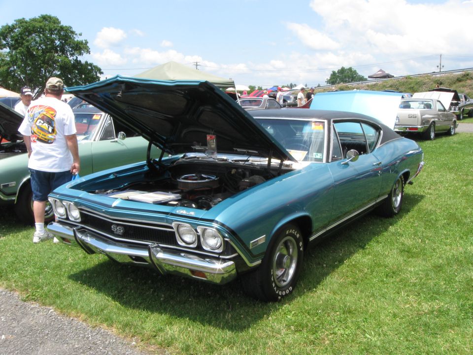 Blue 1969 muscle car, front quarter view, hood open, showing SS badging