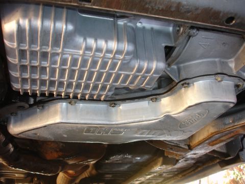 1993 Ford Taurus - Underside view of a vehicle's engine, showing a Ford-branded oil pan and a component labeled 'DHS-ODX'.