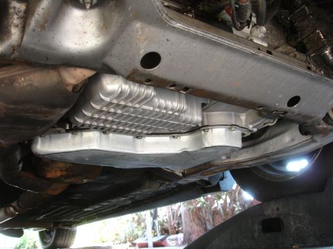 1993 Ford Taurus - The undercarriage of a vehicle is visible, focusing on the transmission pan and surrounding components.