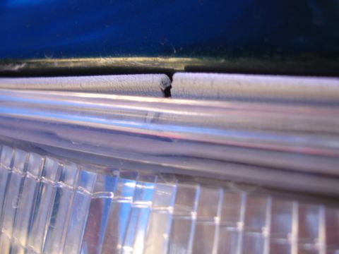 1993 Ford Taurus - Detail of a vehicle's headlight assembly, focusing on the clear lens and surrounding trim.