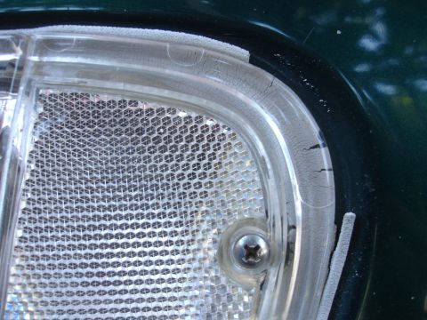 1993 Ford Taurus - Close-up of a vehicle's headlight assembly, showing wear and tear on the plastic components.