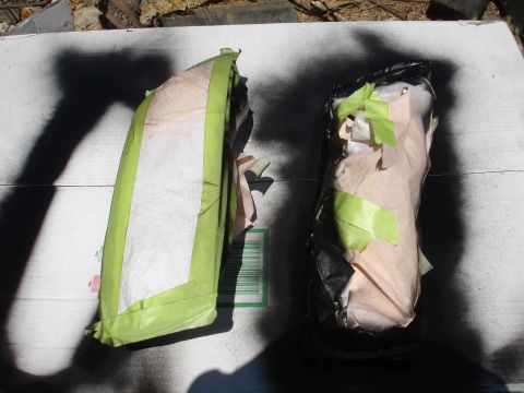 1993 Ford Taurus - Two automotive parts are covered with masking tape and paper, likely for painting or protection.