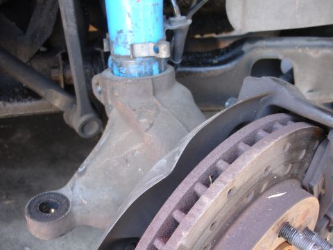 1990 Ford Taurus - This image shows a close-up view of a vehicle's front brake assembly and suspension components.