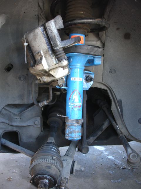 1990 Ford Taurus - Close-up of a vehicle's front suspension and brake system, showing aftermarket components.